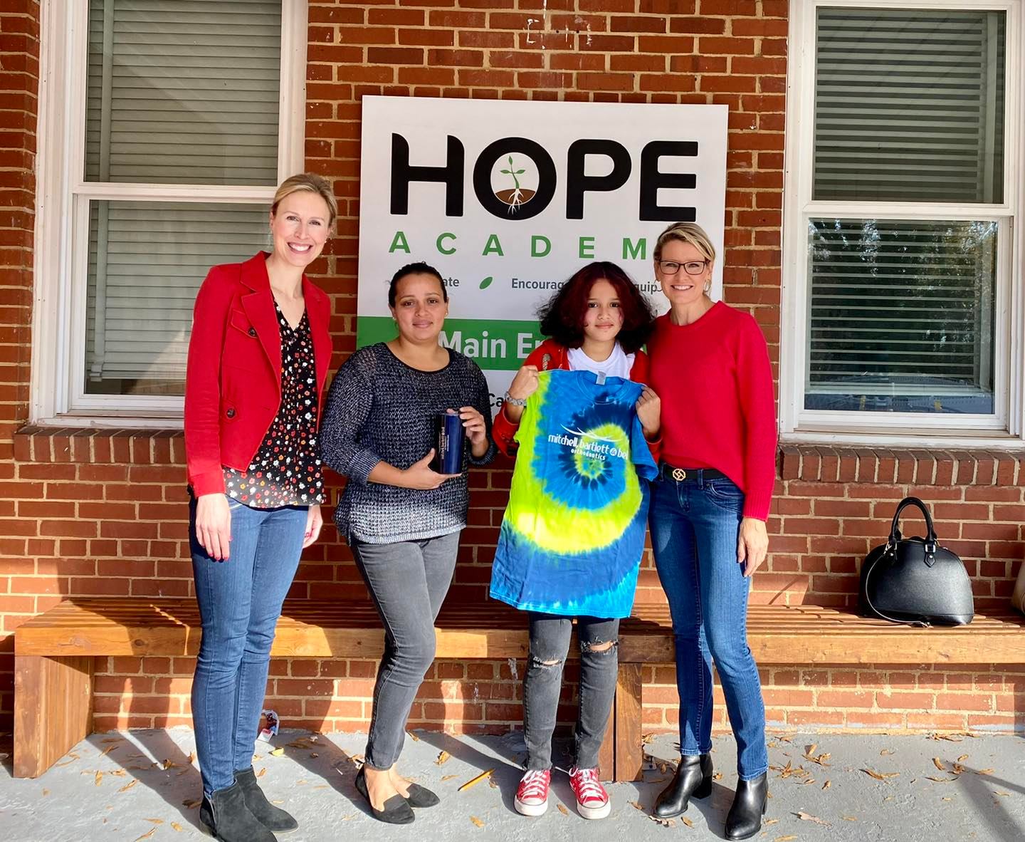 Mitchell, Bartlett & Bell Orthodontics team members with young patient